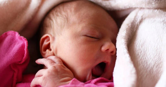 bébé qui baille dans un mini lit