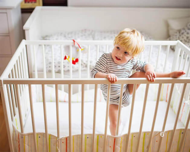 bébé qui escalade son lit barreaux