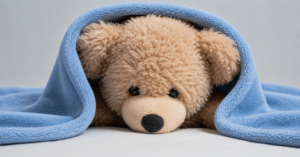 peluche-ourson-sur-un-lit-de-bebe