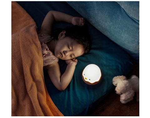 bébé dormant dans son lit avec une veilleuse