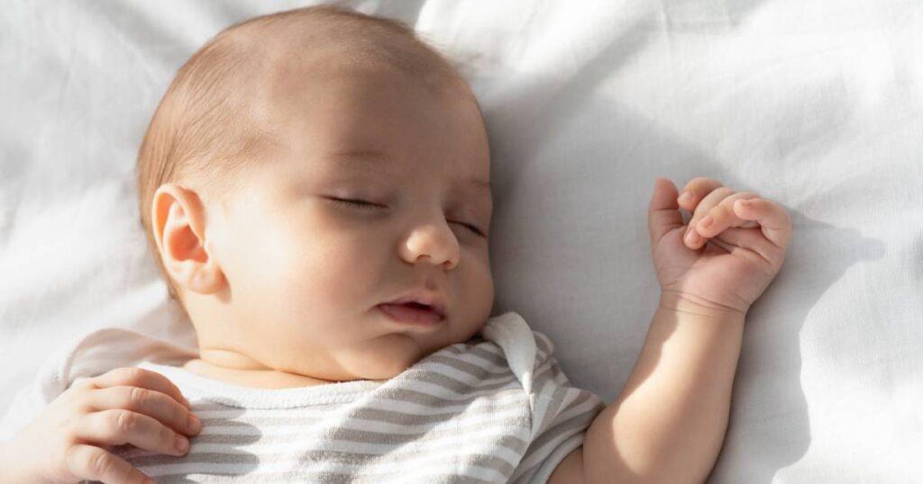 bébé dort paisiblement sur son matelas lit parapluie