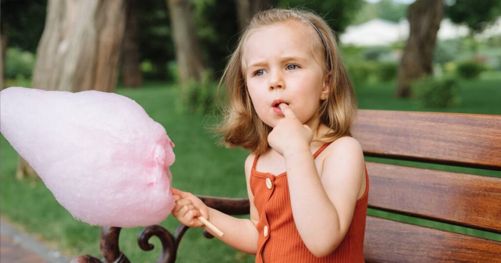 fille mangeant de la barbe à papa
